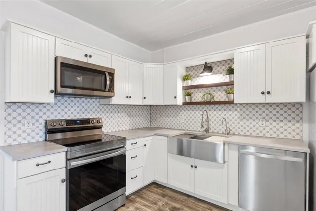 a kitchen with white cabinets stainless steel appliances and sink