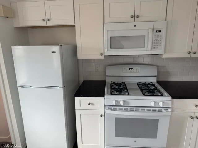 a white stove top oven sitting inside of a kitchen