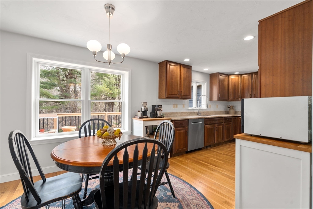 10 Wright Road Sudbury, MA 01776 - Photo 5 of 27 a kitchen with granite countertop a table chairs a sink dishwasher a dining table and chairs with wooden floor