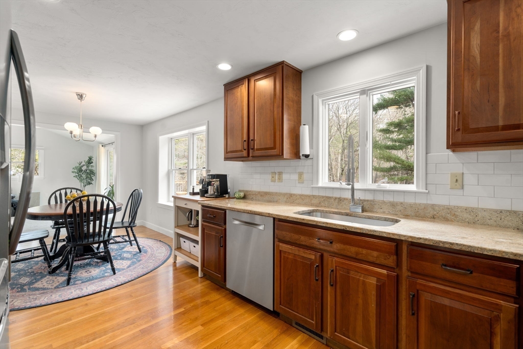 10 Wright Road Sudbury, MA 01776 - Photo 7 of 27 a kitchen with stainless steel appliances granite countertop wooden cabinets a sink a stove a dining table and chairs