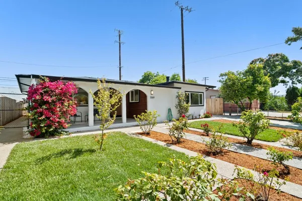 a view of a house with backyard and sitting area