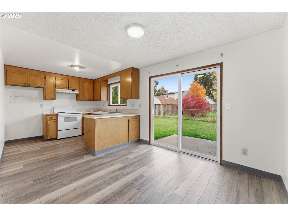 20385 Southwest Shelley Court Beaverton, OR 97078 - Photo 5 of 21 a open kitchen with stainless steel appliances granite countertop a stove top oven a sink with granite countertops and cabinets