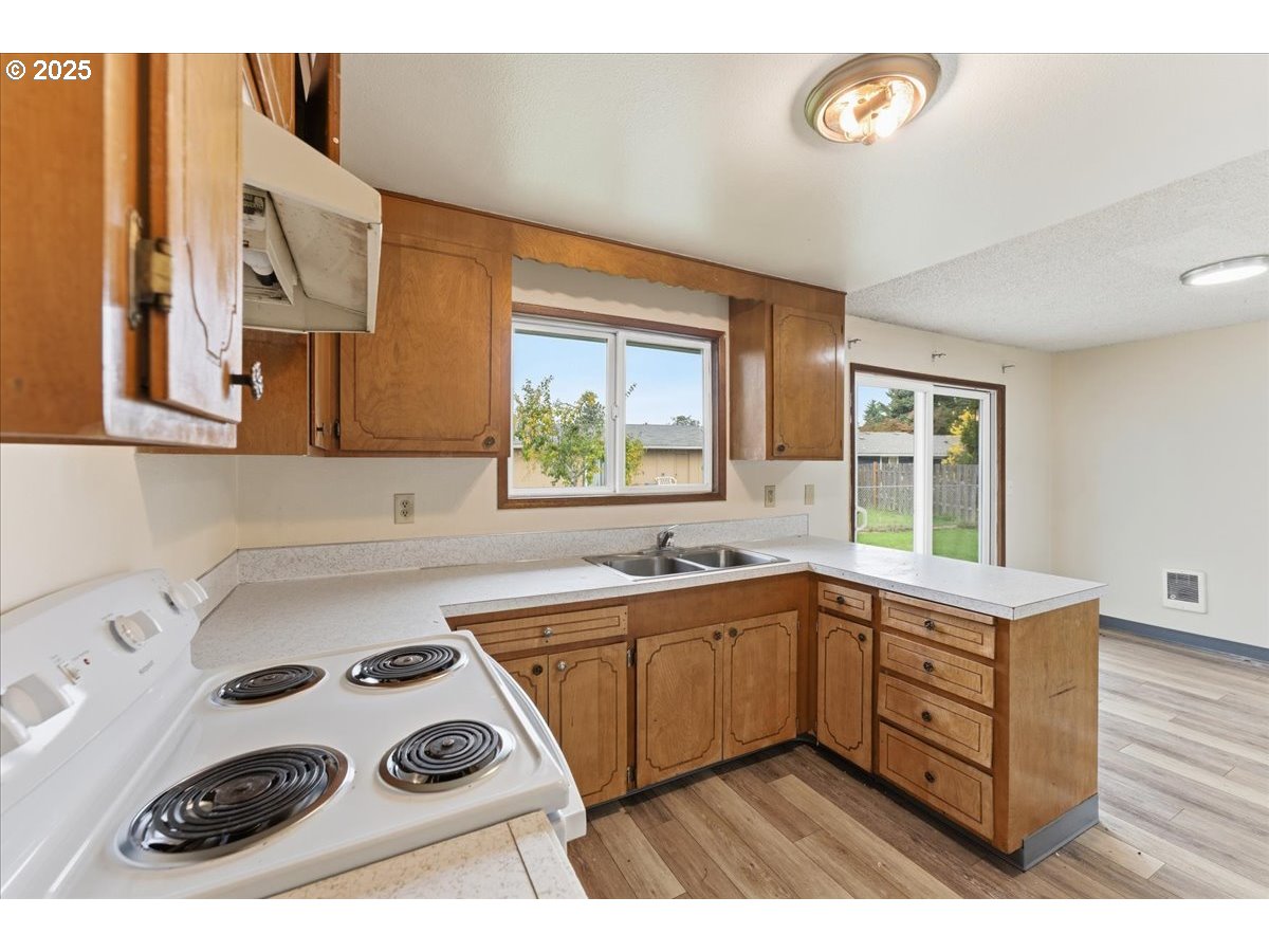 20385 Southwest Shelley Court Beaverton, OR 97078 - Photo 7 of 21 a kitchen with a sink a stove and wooden cabinets