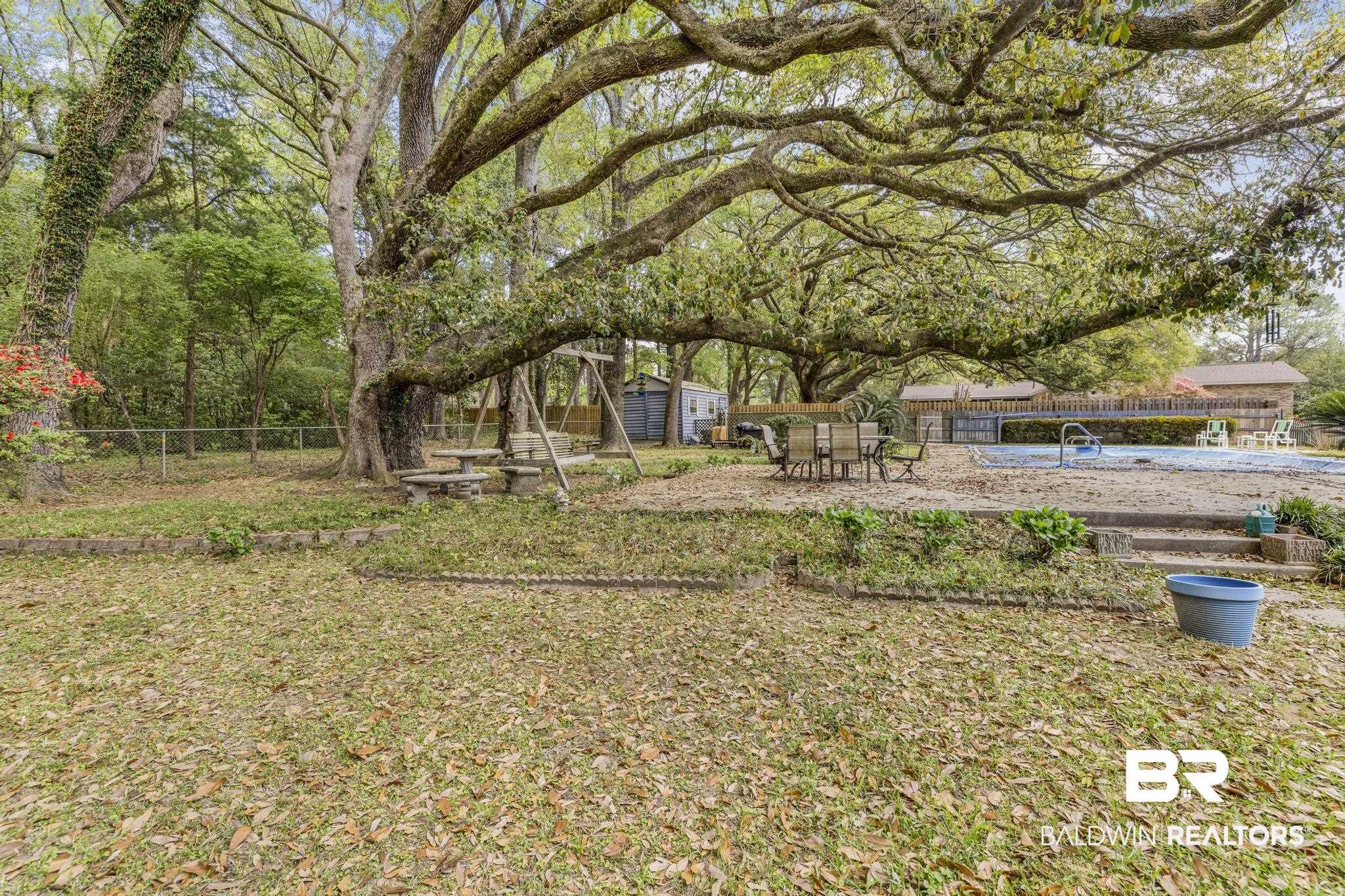10207 Plantation Drive Daphne, AL 36526 - Photo 10 of 48 Fenced backyard with a storage shed, a patio area, and outdoor dining area