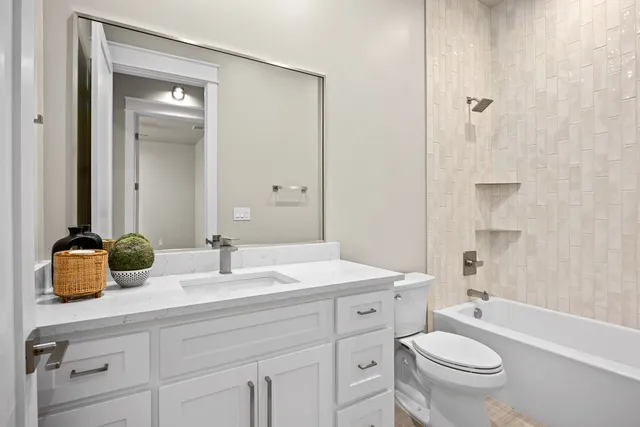 a bathroom with a double vanity sink toilet mirror and shower