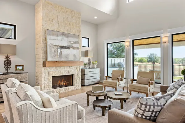 a living room with furniture fireplace and a large window