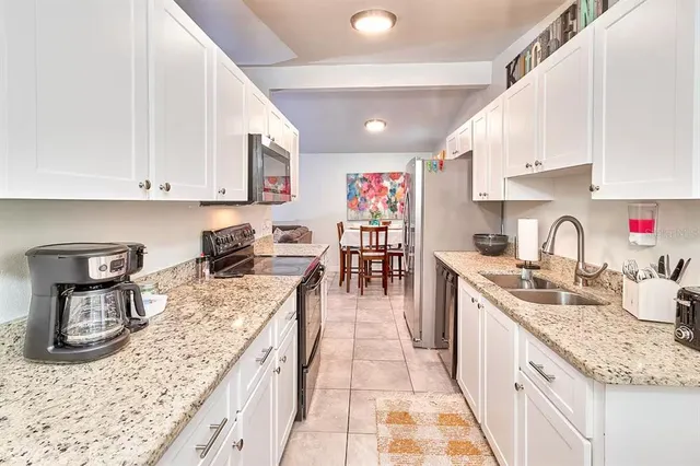 a kitchen with stainless steel appliances granite countertop a sink stove and cabinets