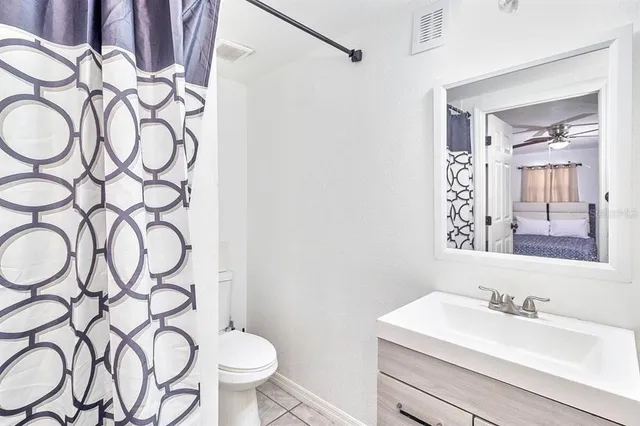 a bedroom with a white bed and a chandelier