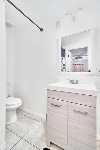 a bathroom with a granite countertop sink a toilet and bathtub