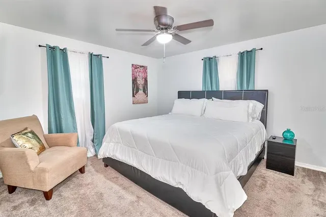 a bedroom with a bed and a ceiling fan