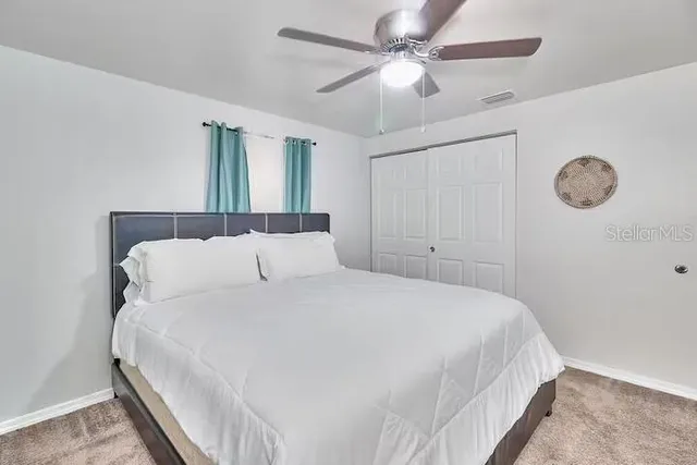 a bedroom with a bed and a flat tv screen on dresser