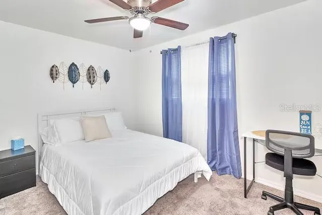 a bedroom with a bed and a chandelier fan
