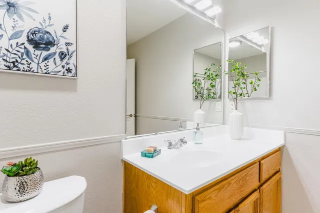 a bathroom with a granite countertop sink and a mirror
