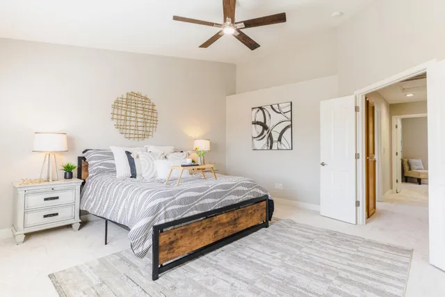a bedroom with a large bed and a painting on the wall