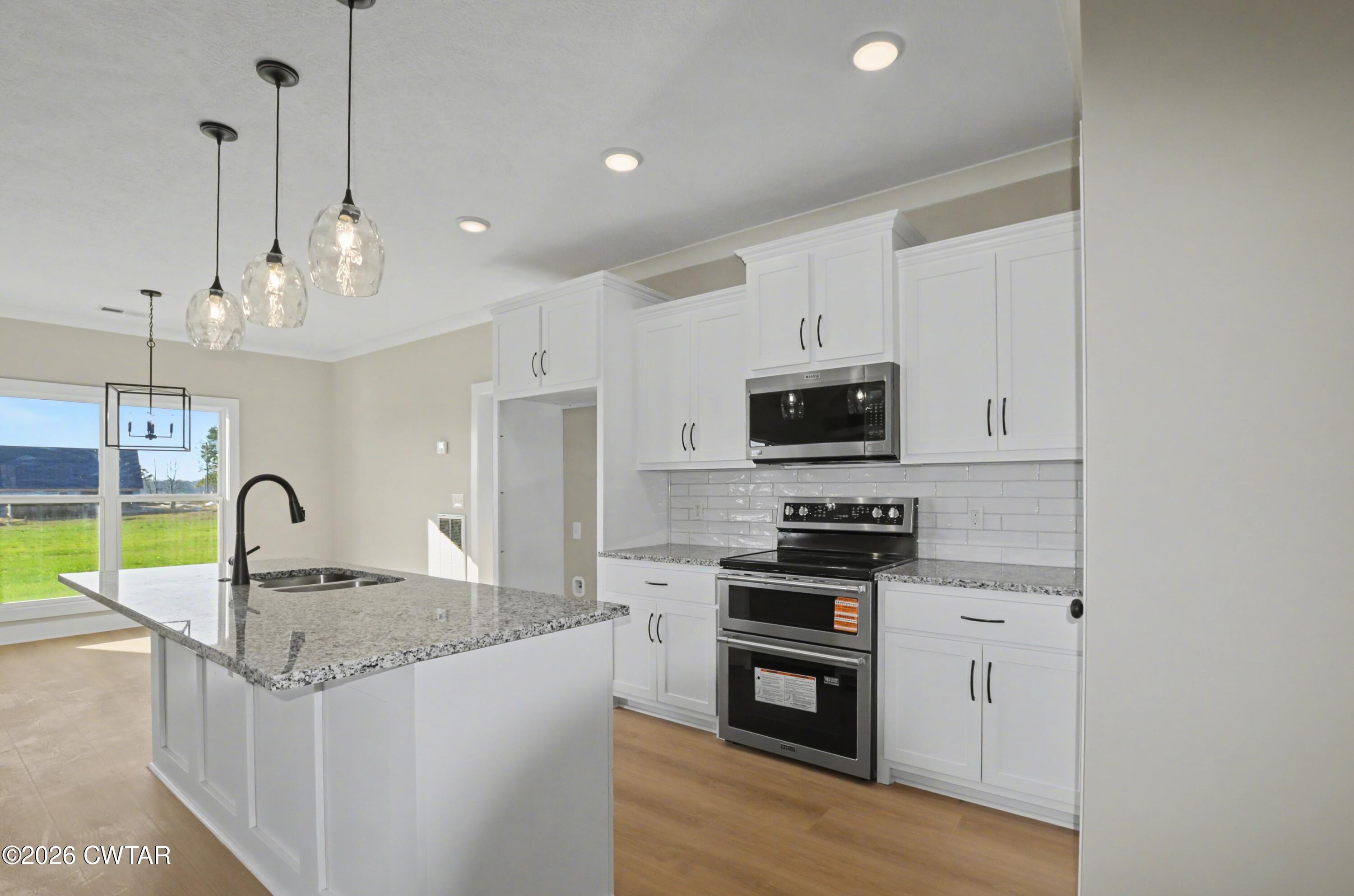 339 Marlow Cemetery Road Gadsden, TN 38337 - Photo 9 of 28 a kitchen with granite countertop a stove a sink and a refrigerator