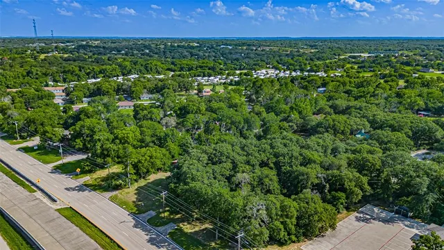 an aerial view of residential houses with outdoor space and trees