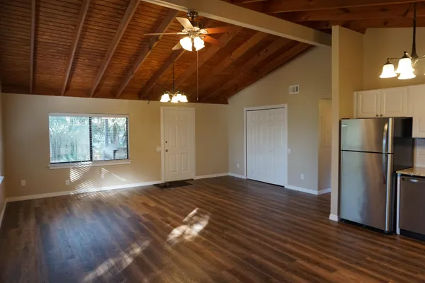 a view of empty room with wooden floor and fan