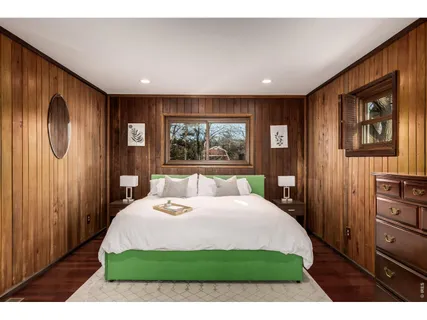 a bedroom with a large bed and a large mirror