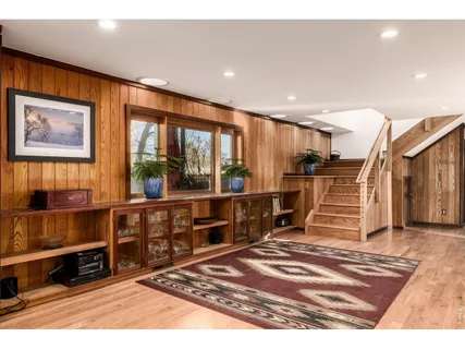 a living room with furniture a wooden floor and next to a window