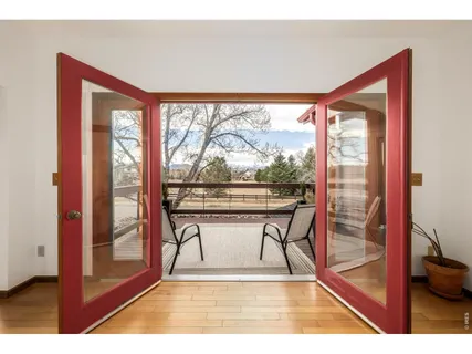 a view of a room with a large window and wooden floor