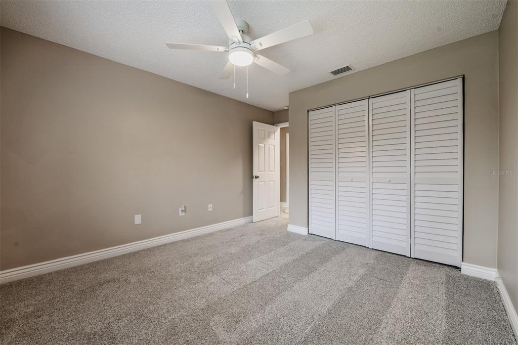 1801 East Lake Road South, Unit 6D Palm Harbor, FL 34685 - Photo 20 of 24 an empty room with closet and a ceiling fan