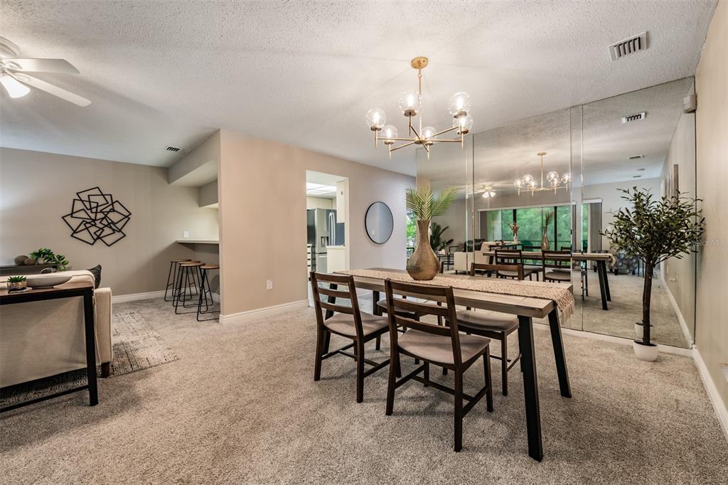 1801 East Lake Road South, Unit 6D Palm Harbor, FL 34685 - Photo 8 of 24 a view of a dining room with furniture and chandelier