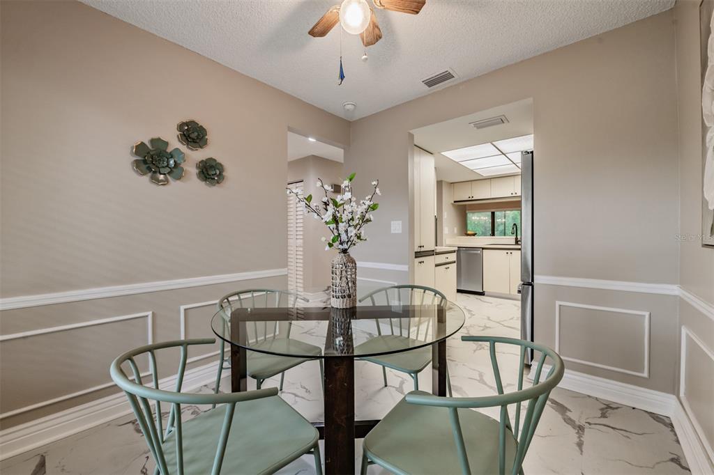 1801 East Lake Road South, Unit 6D Palm Harbor, FL 34685 - Photo 9 of 24 a dining room with furniture and window