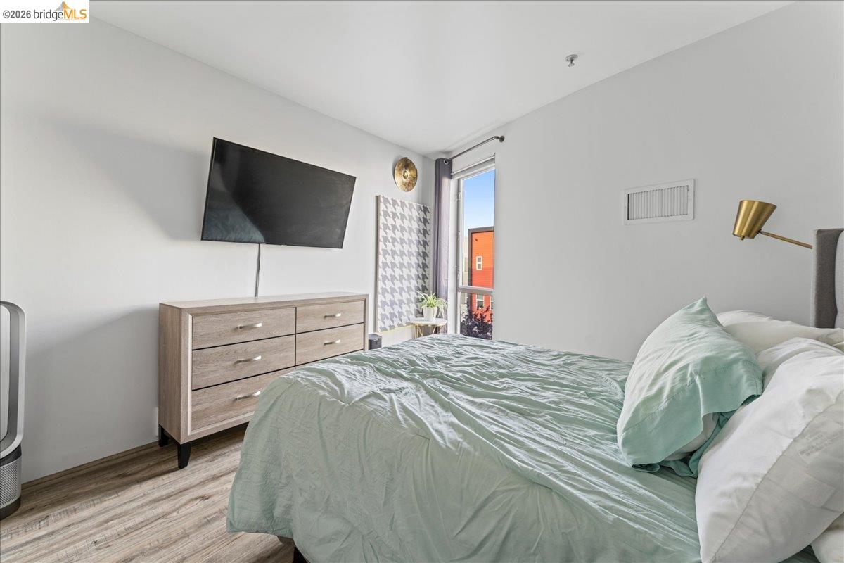 1201 Pine Street, Unit 354 Oakland, CA 94607 - Photo 11 of 26 a bedroom with a bed and a flat screen tv