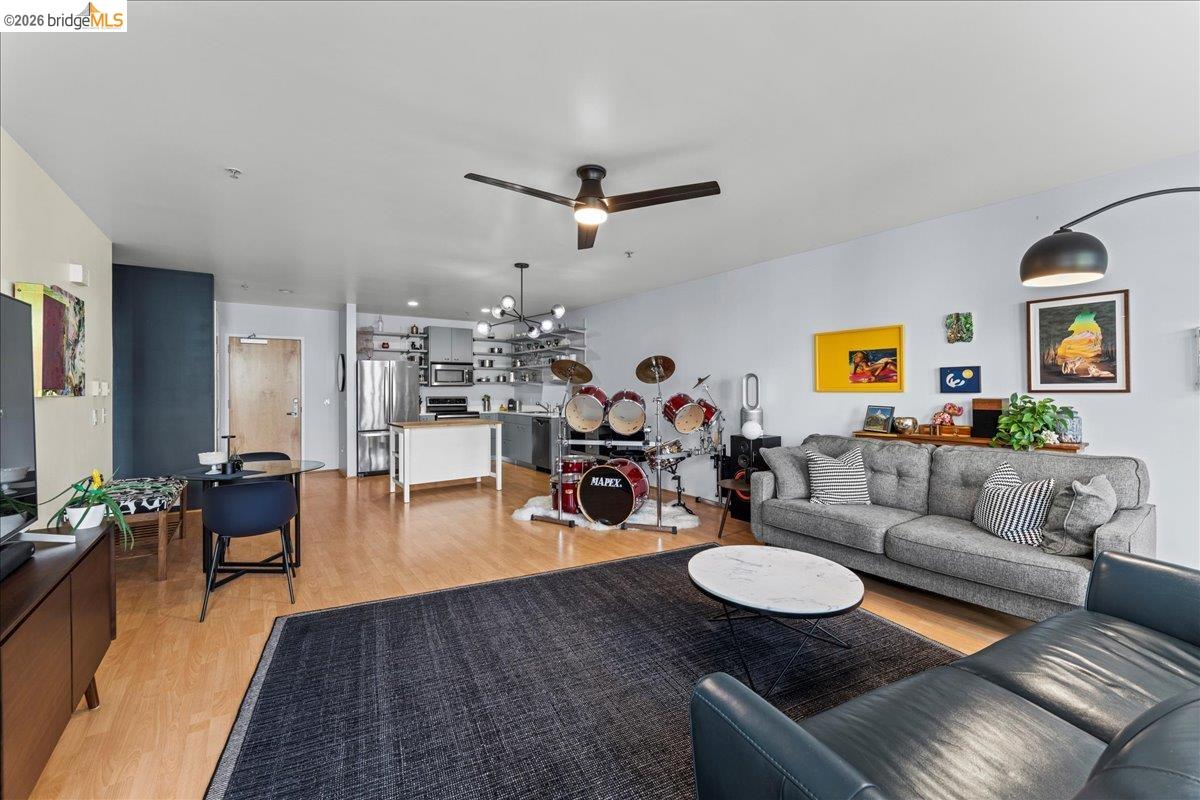 1201 Pine Street, Unit 354 Oakland, CA 94607 - Photo 24 of 26 a living room with furniture kitchen view and a wooden floor