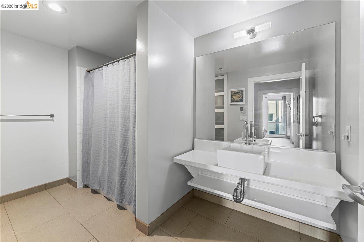 1201 Pine Street, Unit 354 Oakland, CA 94607 - Photo 26 of 26 a bathroom with a sink and a mirror