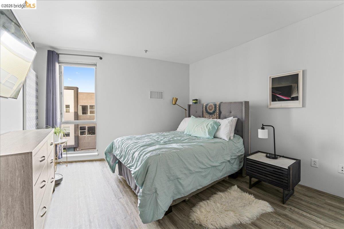 1201 Pine Street, Unit 354 Oakland, CA 94607 - Photo 9 of 26 a bedroom with a bed lamp and a window