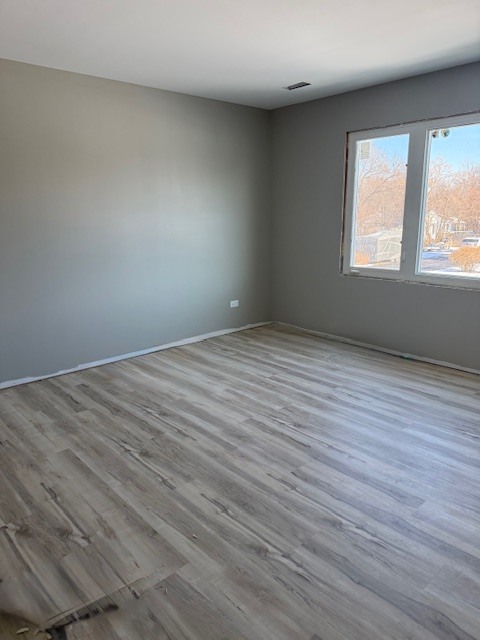 7128 Cork Avenue Justice, IL 60458 - Photo 12 of 17 a view of an empty room with wooden floor and a window