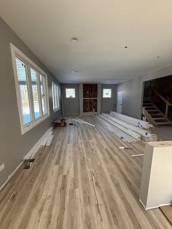 a view of an empty room with a window and a kitchen