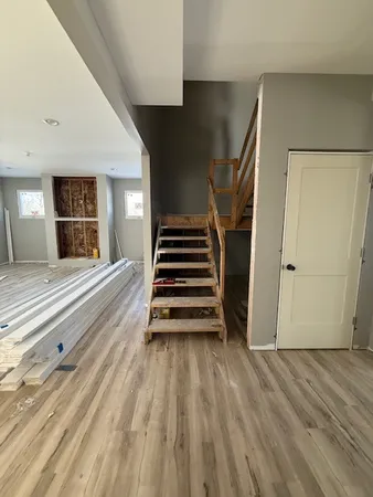 a view of a hardwood floor and stairs in a room