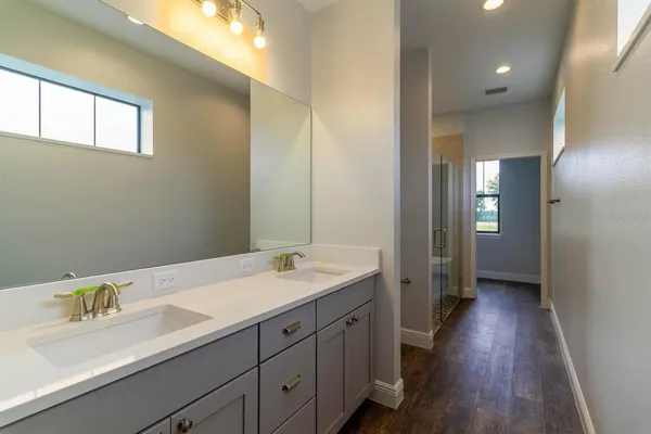 a en suite bathroom with a double vanity sink and a mirror