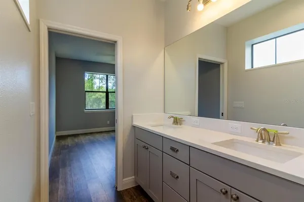 a en suite bathroom with a granite countertop sink and a mirror