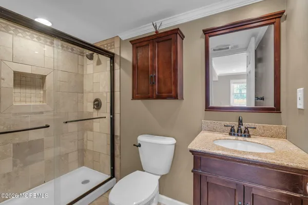 a bathroom with a granite countertop sink toilet and shower