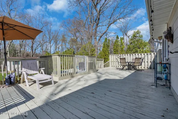 a view of a patio with wooden floor table and chairs