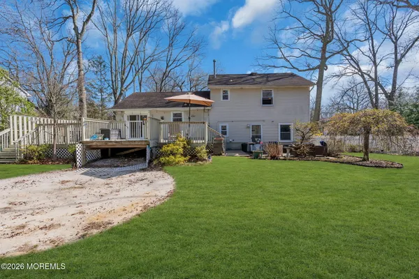 a front view of a house with a garden and trees