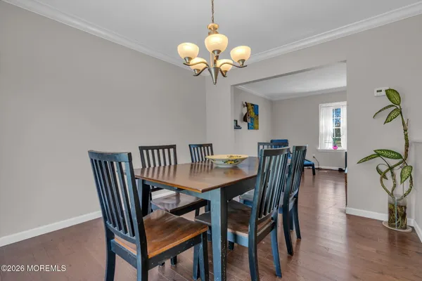 a dining room with furniture potted plants and wooden floor
