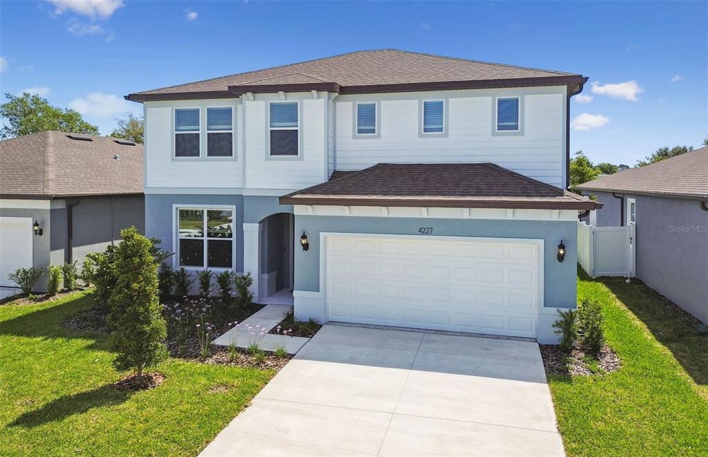 a front view of a house with a yard and garage