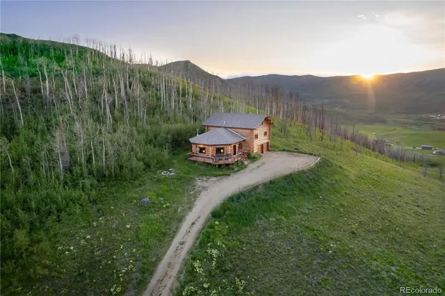 a kitchen with stainless steel appliances granite countertop a stove a sink dishwasher and white cabinets with wooden floor