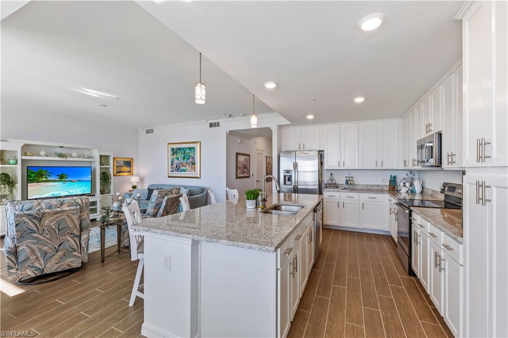 43010 Greenway Boulevard, Unit 237 Punta Gorda, FL 33982 - Photo 6 of 11 a kitchen with stainless steel appliances granite countertop a refrigerator a stove top oven a sink dishwasher and white cabinets with wooden floor