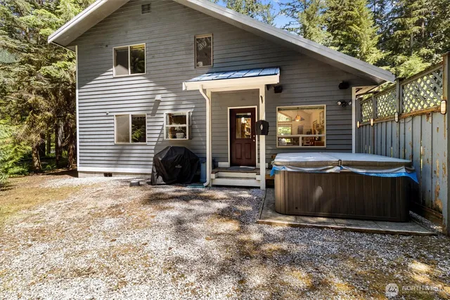 a front view of a house with a yard outdoor seating and covered with trees