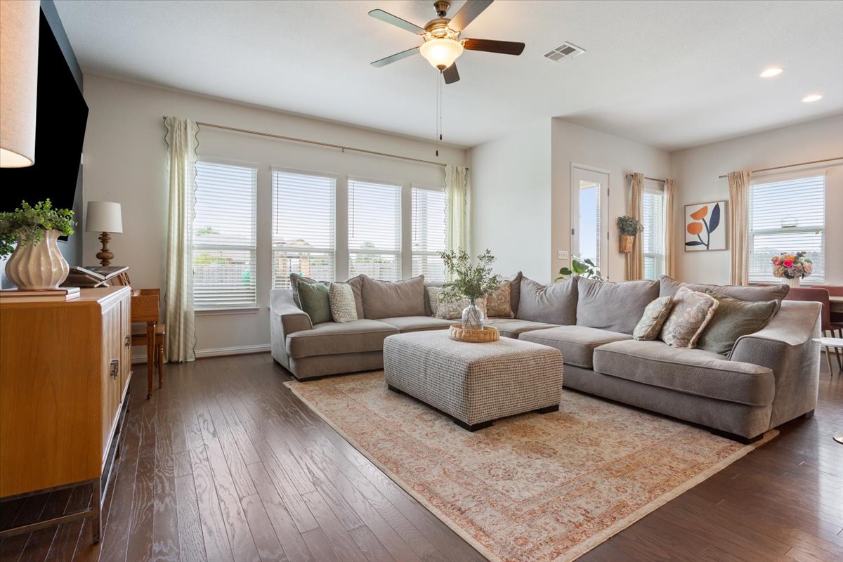 424 Millard Street Georgetown, TX 78628 - Photo 10 of 37 Rich hardwood floors complement this inviting living space, framed by large windows offering abundant natural illumination.
