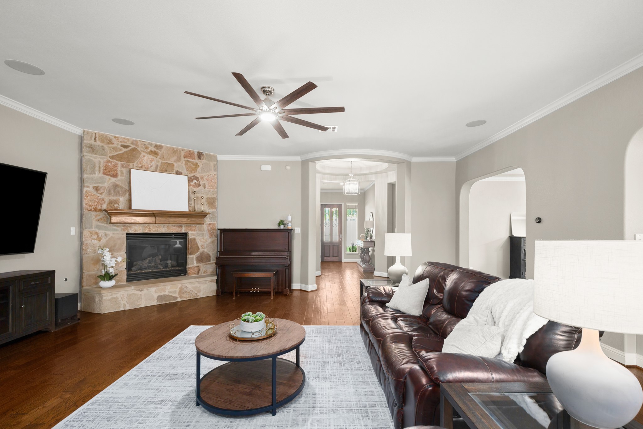 502 Spring Arbor Lane Cedar Park, TX 78613 - Photo 9 of 40 Featuring a striking corner fireplace nestled in a stone hearth with a wood mantel.