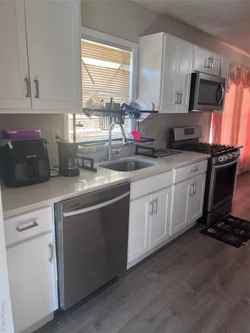 a kitchen with stainless steel appliances a sink stove and cabinets