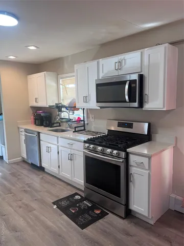 a kitchen with stainless steel appliances a stove a microwave and cabinets