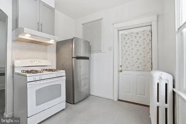 a kitchen with a stove a refrigerator and a cabinets