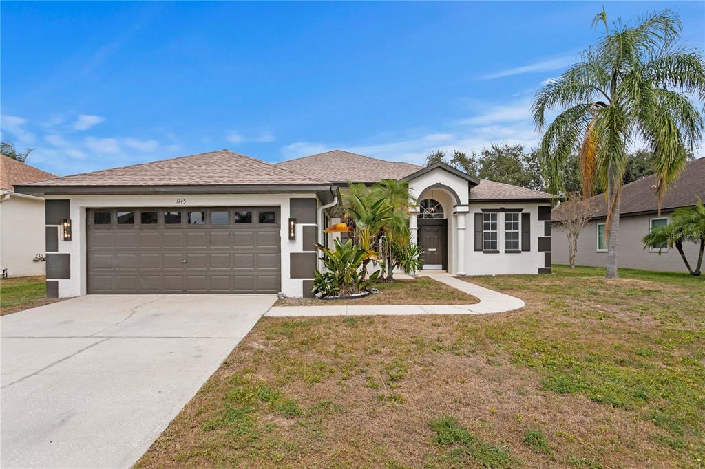 1145 Riveredge Drive Tarpon Springs, FL 34689 - Photo 1 of 1 a front view of a house with a yard